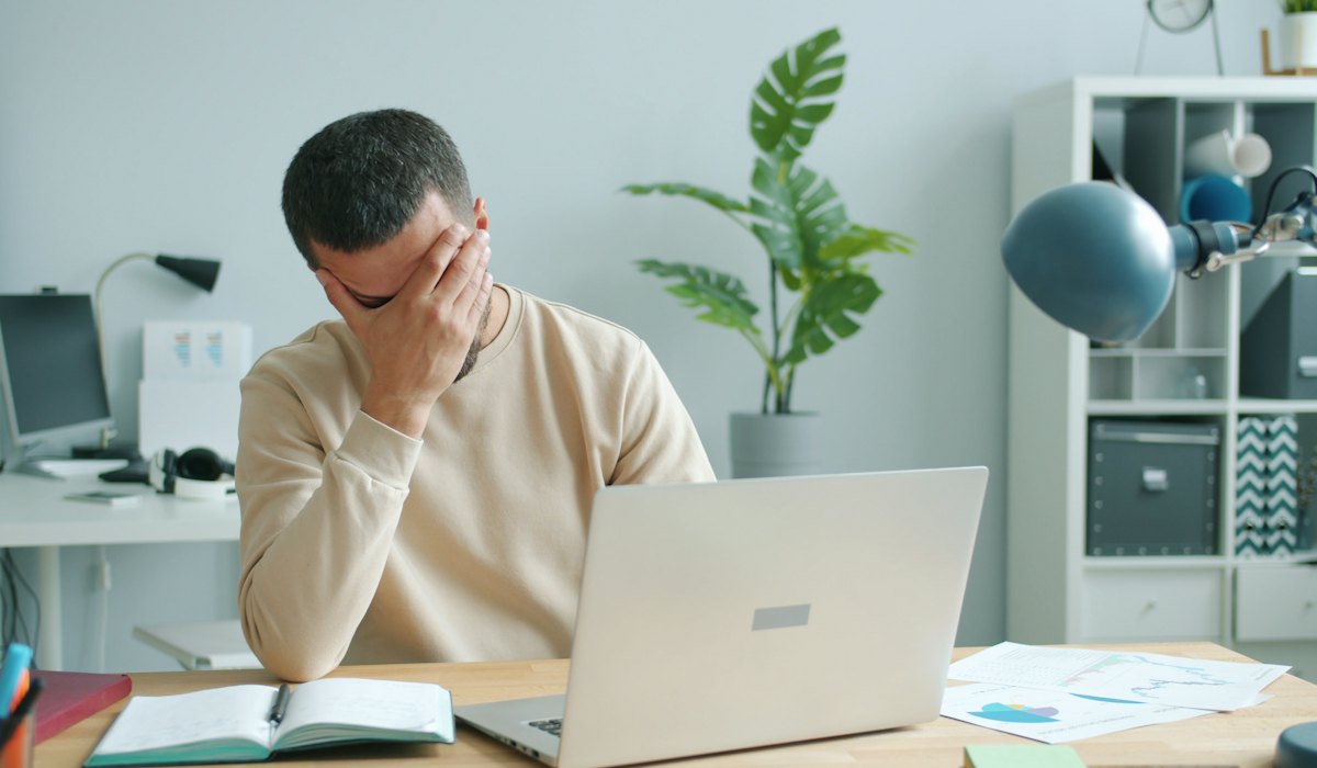 Homem frustrado diante do notebook, sem acesso à conta de e-mail